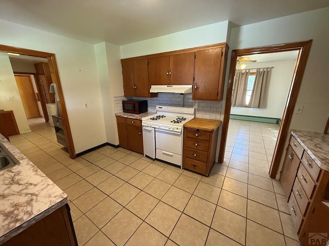 480 W 9th Ave, Lamar, CO 81073 - kitchen featuring white gas range oven, under cabinet range hood, black microwave, baseboard heating, and light tile patterned floors