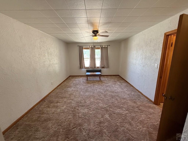 480 W 9th Ave, Lamar, CO 81073 - carpeted spare room with a textured wall, ceiling fan, a paneled ceiling, and baseboards