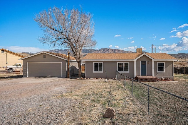 ranch-style house with a garage, fence, and concrete driveway