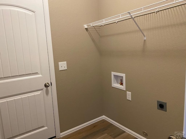 washroom with dark wood-style floors, baseboards, hookup for an electric dryer, hookup for a washing machine, and laundry area