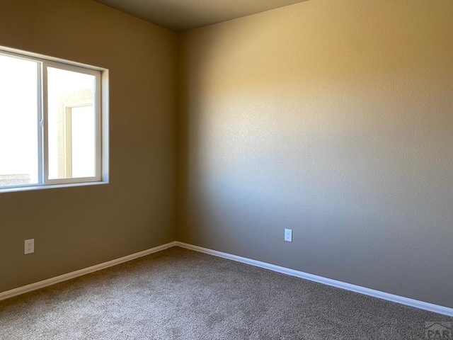 empty room featuring carpet flooring and baseboards