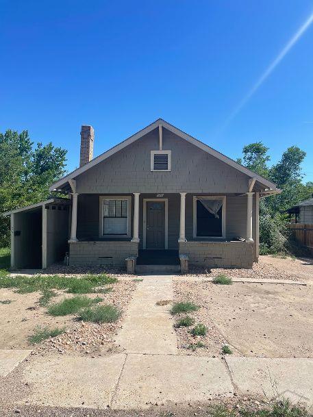 view of front of property with a porch and a chimney