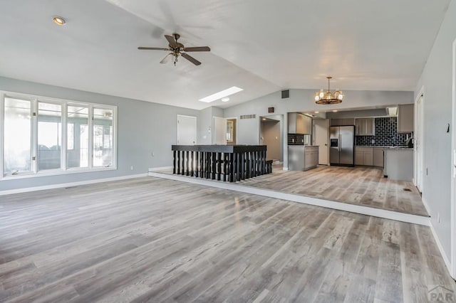 862 S Los Mochis Way, Pueblo, CO 81007 - unfurnished living room featuring lofted ceiling, ceiling fan, light wood finished floors, a chandelier, and a skylight