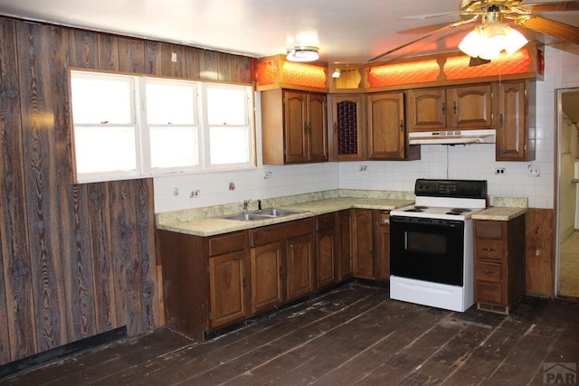 kitchen featuring under cabinet range hood, a sink, electric stove, dark wood-style floors, and tasteful backsplash