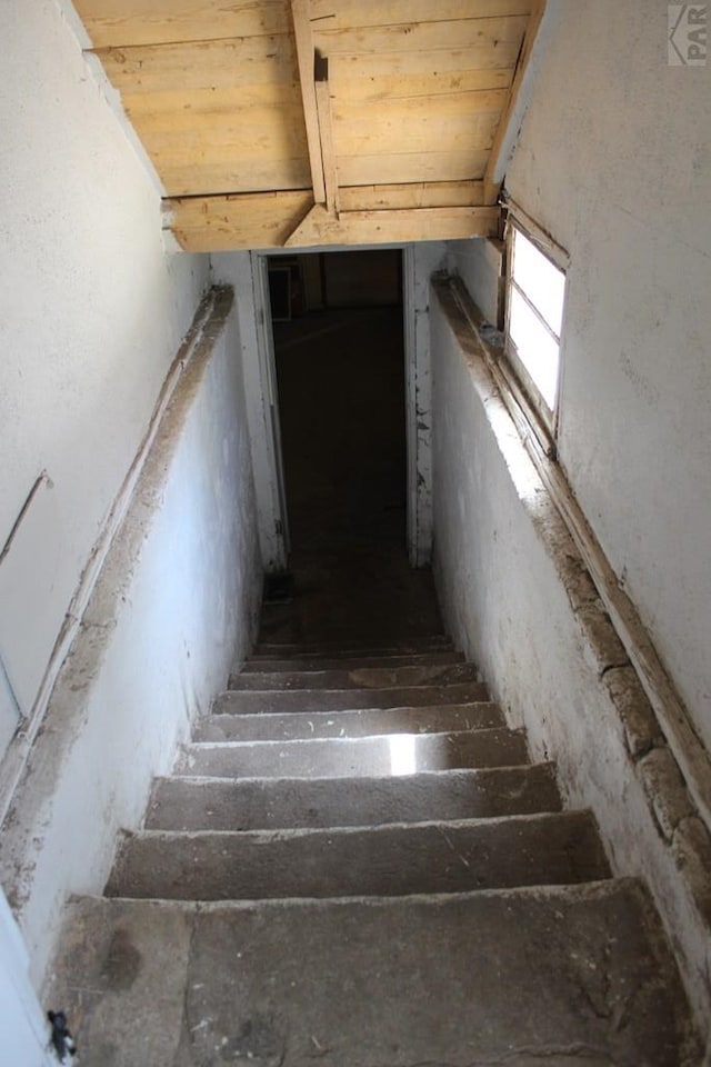 stairs featuring lofted ceiling and wooden ceiling