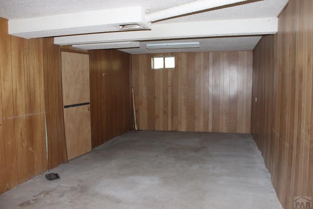 basement featuring wooden walls