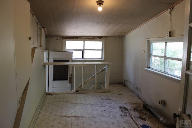 kitchen with plenty of natural light, vaulted ceiling, and tile patterned floors