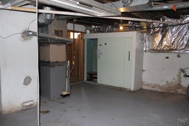 unfinished basement featuring heating unit