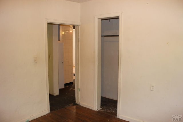 unfurnished bedroom with a closet, baseboards, and wood finished floors