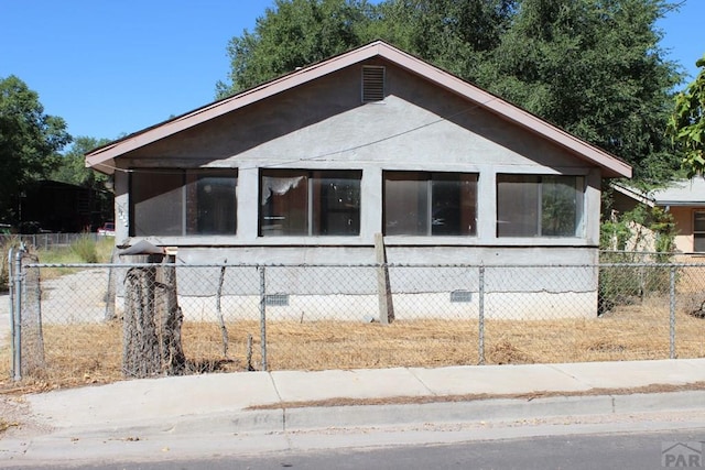 exterior space with a fenced front yard, crawl space, and a sunroom