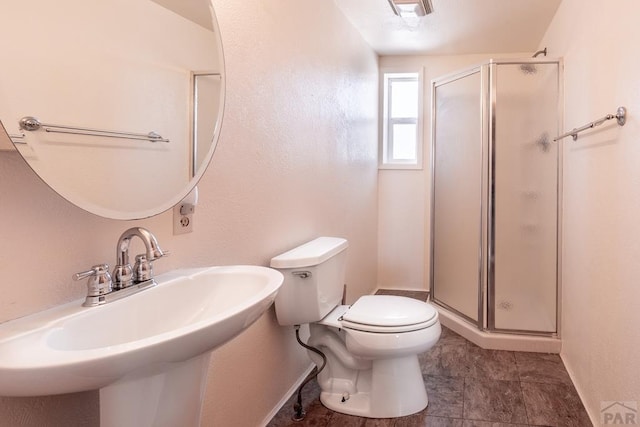 full bathroom with a stall shower, baseboards, visible vents, toilet, and a sink