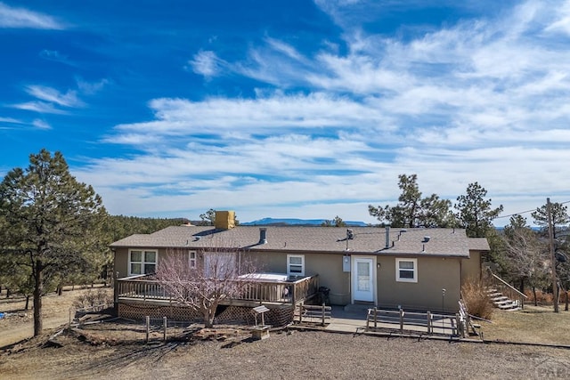 back of house with a deck and stucco siding