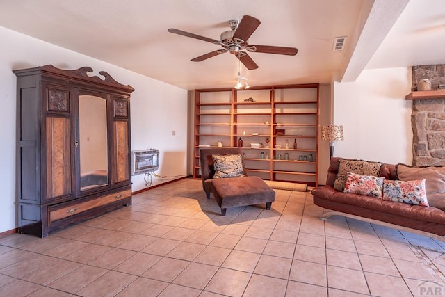 sitting room featuring built in features, visible vents, a ceiling fan, heating unit, and light tile patterned flooring