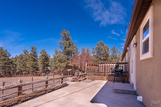 view of patio featuring fence and a wooden deck