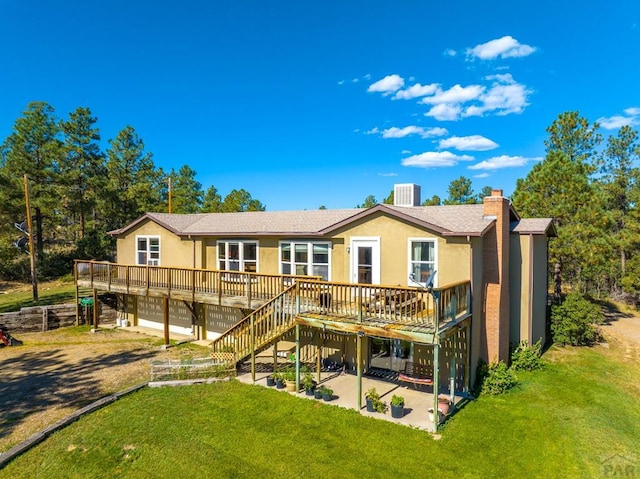 back of house with a patio area, a yard, central AC, and stucco siding