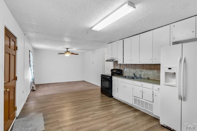 kitchen featuring white fridge with ice dispenser, black range with electric cooktop, light countertops, and white cabinetry