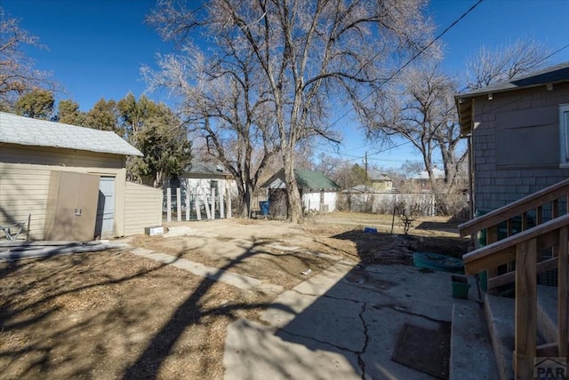 view of yard featuring fence and an outbuilding