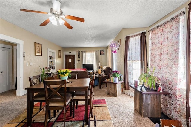 dining room featuring carpet, a ceiling fan, and a textured ceiling