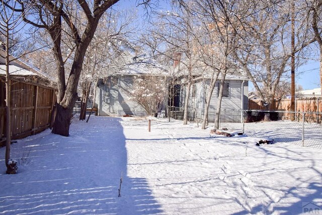 yard layered in snow with a fenced backyard