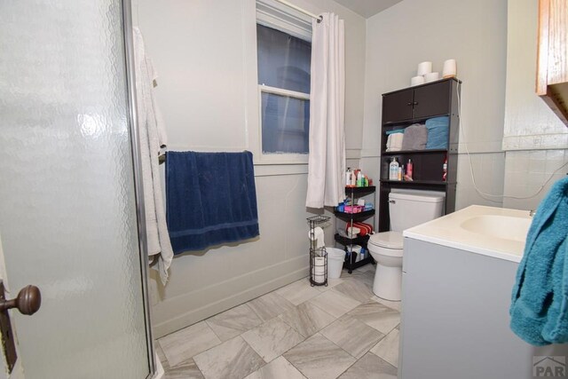 bathroom with toilet, a stall shower, and vanity