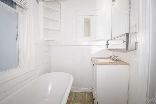 full bath with a freestanding tub, tile patterned floors, and vanity