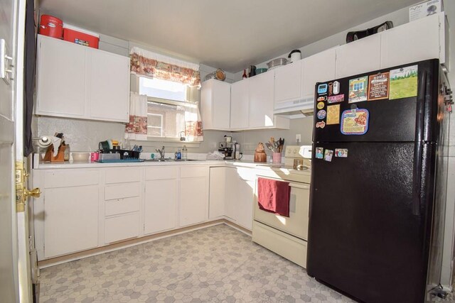 kitchen with under cabinet range hood, white cabinetry, light countertops, freestanding refrigerator, and white range with electric cooktop