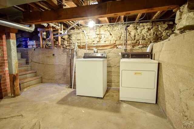 unfinished basement featuring washing machine and clothes dryer