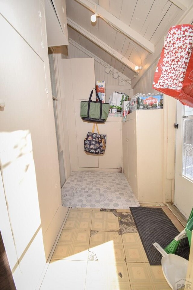 hallway with lofted ceiling with beams, wood ceiling, and tile patterned floors