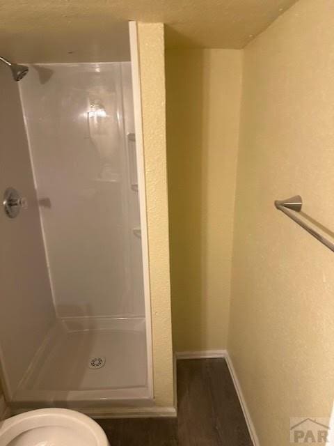 bathroom with a stall shower and baseboards