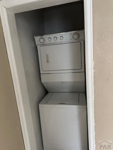 laundry room with stacked washing maching and dryer