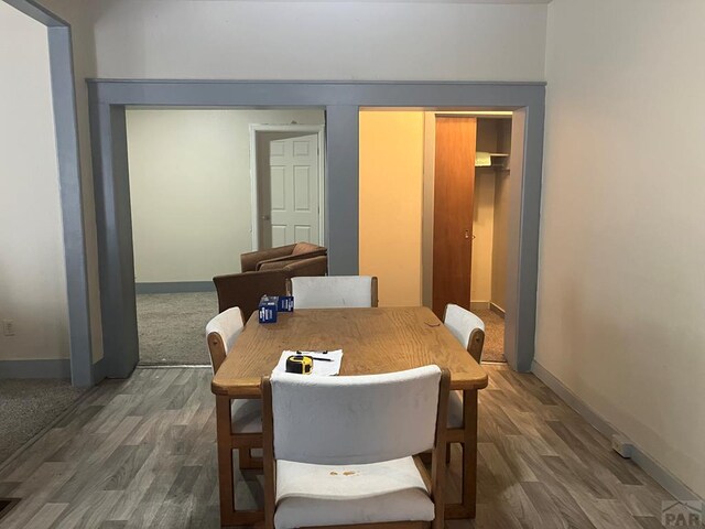 dining area featuring dark wood-style flooring and baseboards