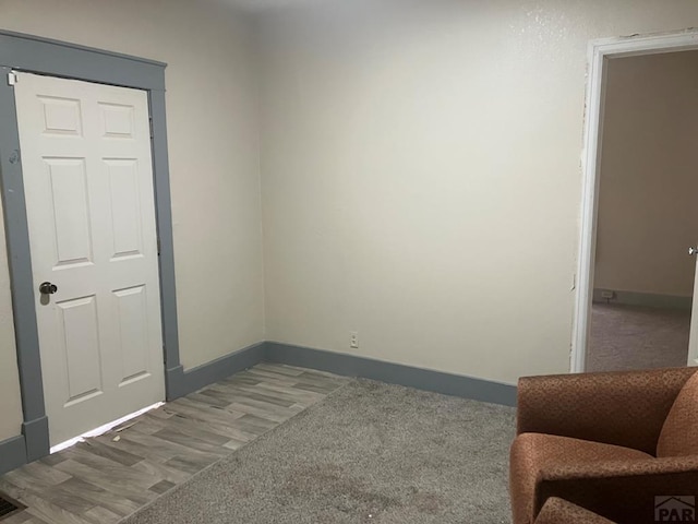 spare room featuring wood finished floors and baseboards