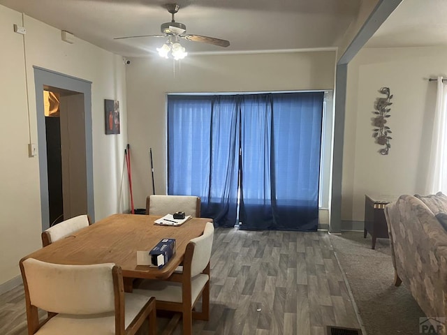 dining area featuring a ceiling fan, baseboards, and wood finished floors