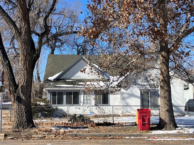 view of front of home featuring a fenced front yard and roof with shingles