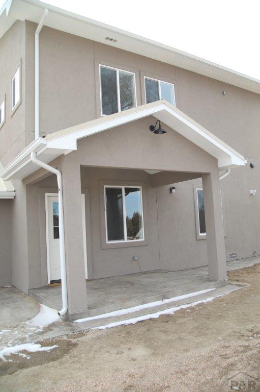 back of property featuring stucco siding