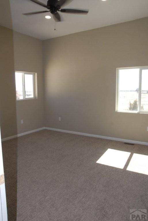 carpeted empty room featuring baseboards and recessed lighting