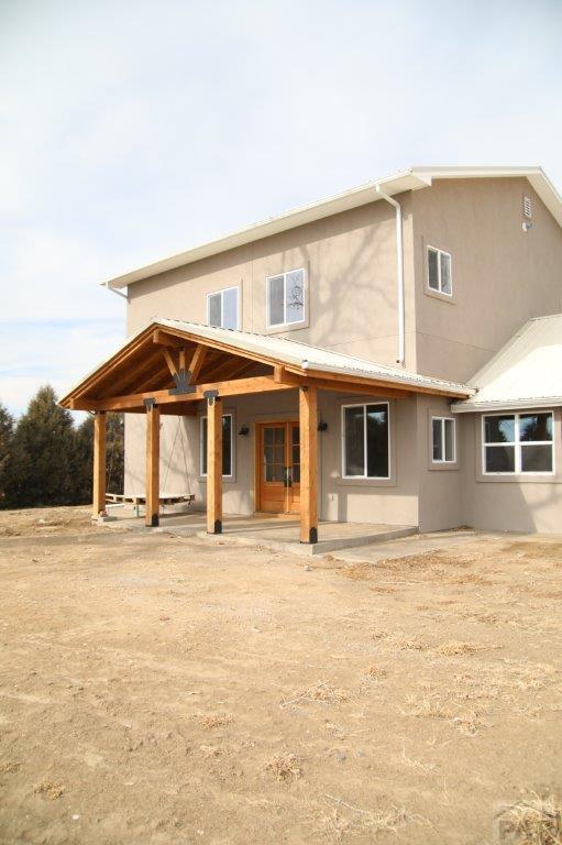 back of property with metal roof, a patio, and stucco siding