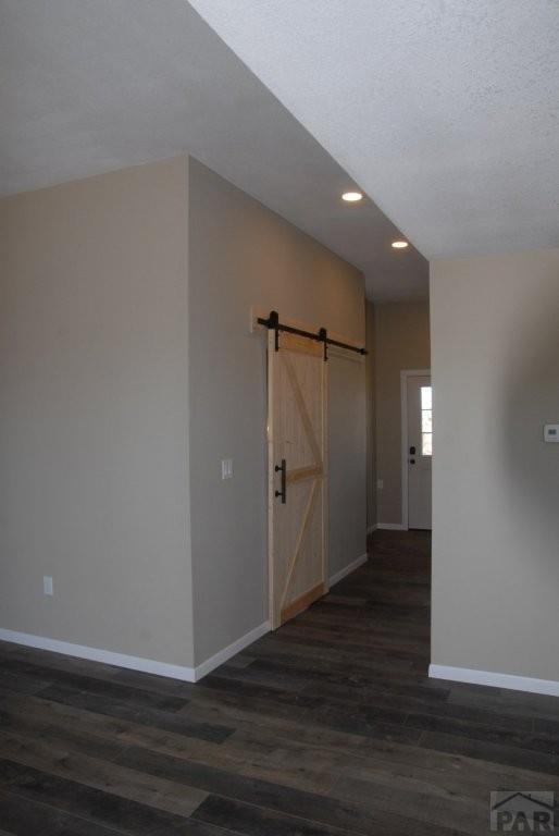 bathroom featuring toilet, wood finished floors, vanity, and baseboards