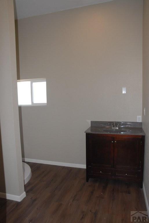 kitchen with white cabinetry, freestanding refrigerator, a center island, a kitchen bar, and pendant lighting