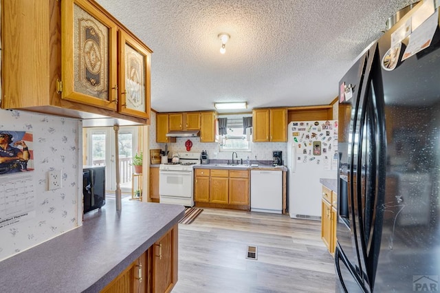 8417 3r Rd, Beulah, CO 80123 - kitchen featuring white appliances, under cabinet range hood, a sink, healthy amount of natural light, and wallpapered walls