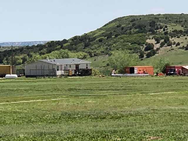 view of yard with a rural view and a mountain view