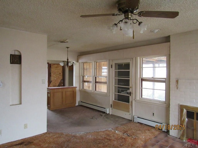 unfurnished dining area with a baseboard heating unit, a textured ceiling, and ceiling fan with notable chandelier