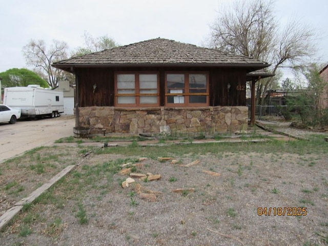 exterior space featuring driveway and stone siding