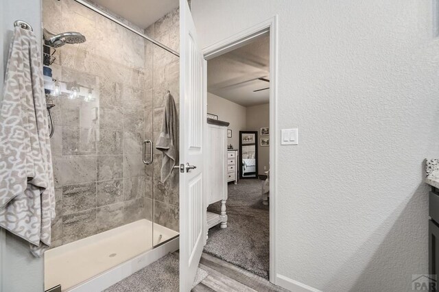 bathroom with a stall shower and a textured wall