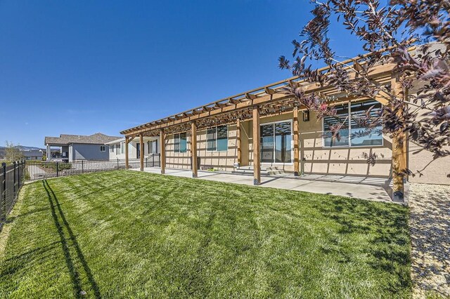 back of property with a patio area, fence, a lawn, and stucco siding