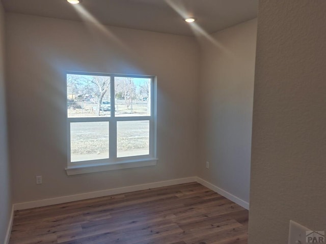 spare room featuring a wealth of natural light, recessed lighting, baseboards, and wood finished floors