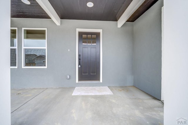 view of exterior entry with a patio area