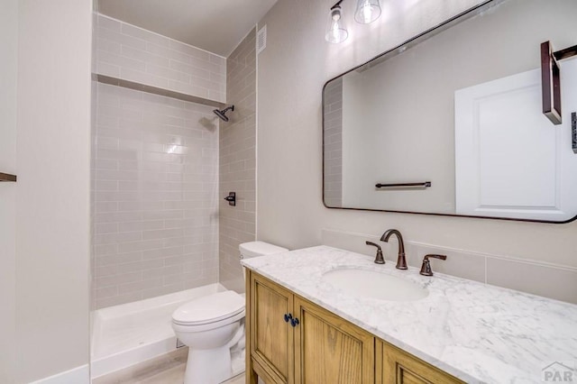 full bath with toilet, a stall shower, and vanity