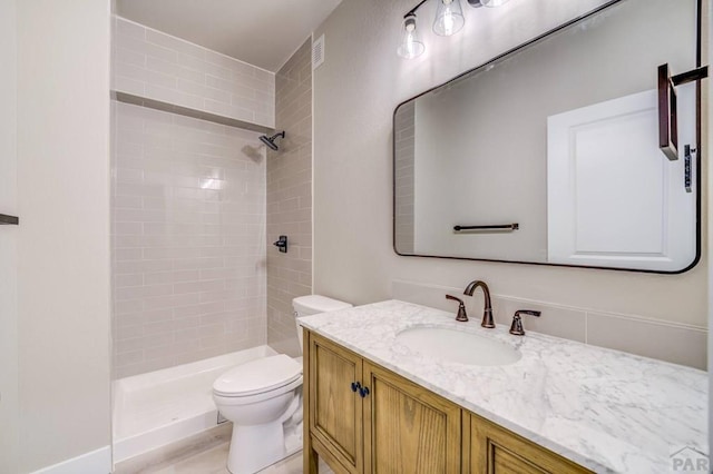 full bathroom featuring a stall shower, vanity, and toilet