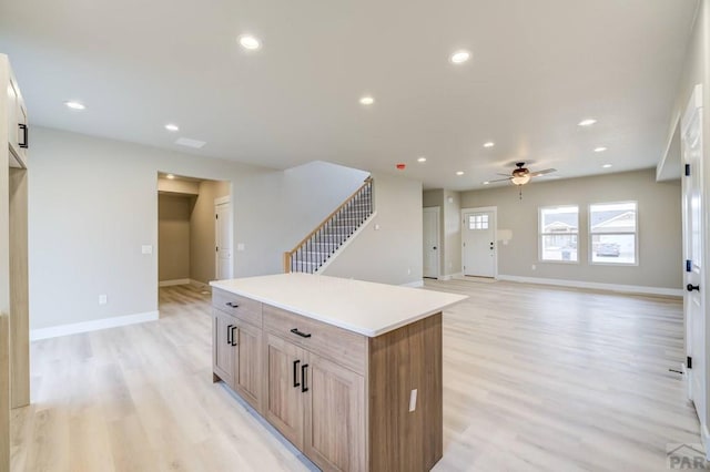 kitchen featuring a center island, recessed lighting, light countertops, light wood-style flooring, and open floor plan